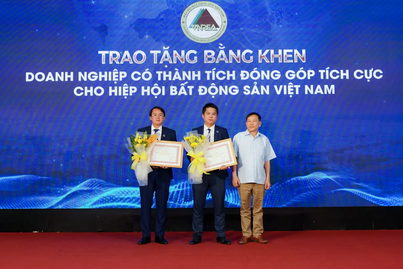 Chủ tịch Hiệp hội BĐS Việt Nam – ông Nguyễn Văn Khôi (bìa phải) trao tặng Bằng khen doanh nghiệp có đóng góp tích cực cho Hiệp hội Bất động sản Việt Nam cho Đất Xanh Miền Tây – thành viên Dat Xanh Services (bên phải)và BĐS Nam Miền Tây – Đất Xanh Miền Tây – thành viên Dat Xanh Services (bên trái)