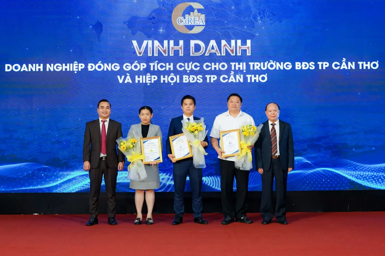 Chủ tịch Dương Quốc Thủy (bìa trái) và Phó Chủ tịch Thường trực Phạm Văn Luận (bìa phải) trao bằng khen cho Doanh nghiệp đóng góp tích cực cho thị trường BĐS TP Cần Thơ và Hiệp hội BĐS TP Cần Thơ – Đất Xanh Miền Tây (ở giữa)